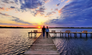 Couple enjoying a sunset walk on the waterfront dock at Tom's Cove Park, a waterfront campground on Chincoteague Island near Assateague Beach.